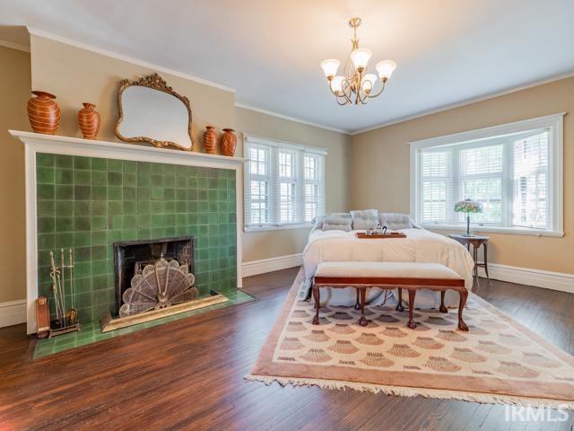 bedroom featuring crown molding, dark wood-type flooring, and multiple windows