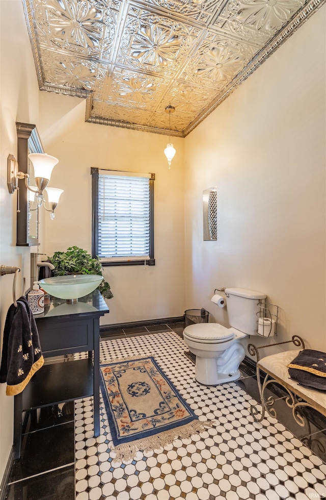 bathroom featuring tile floors, vanity, and toilet