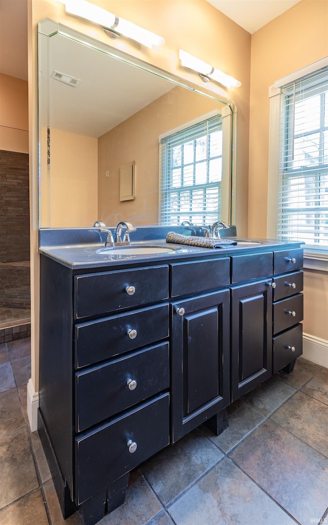 bathroom featuring a wealth of natural light, dual bowl vanity, and tile floors