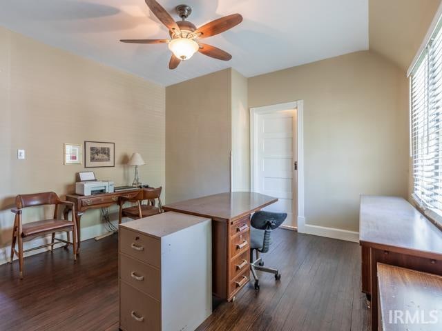 office featuring ceiling fan, vaulted ceiling, and dark wood-type flooring