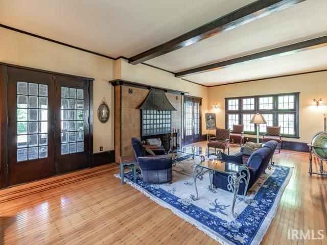 living room featuring beamed ceiling, french doors, and hardwood / wood-style floors