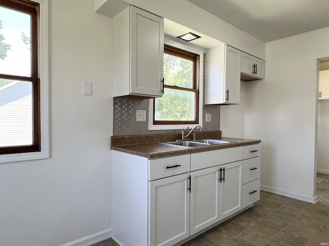 kitchen featuring white cabinets, tasteful backsplash, and sink