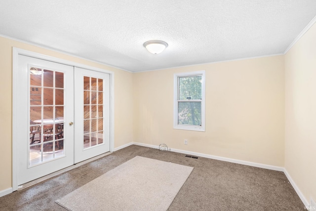 empty room featuring carpet flooring, crown molding, a textured ceiling, and french doors