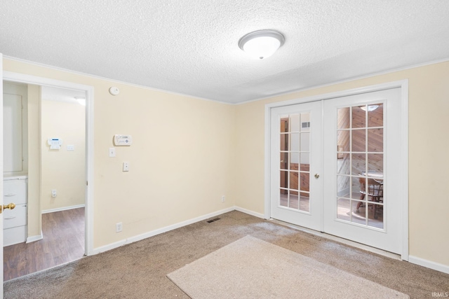 unfurnished room with french doors, carpet floors, and a textured ceiling