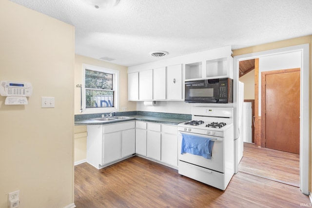 kitchen with white cabinets, dark hardwood / wood-style floors, white range with gas stovetop, and sink