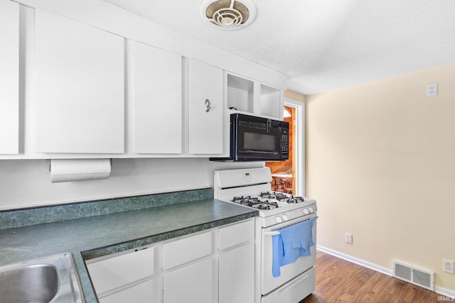 kitchen featuring white cabinets, dark hardwood / wood-style flooring, white gas range oven, and a textured ceiling