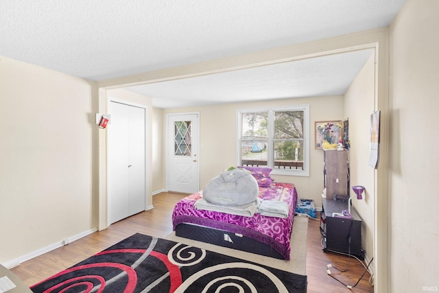 bedroom featuring a textured ceiling and light wood-type flooring