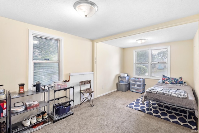 bedroom with light colored carpet and a textured ceiling