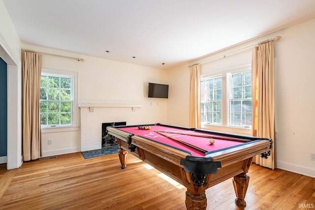 rec room featuring pool table, light hardwood / wood-style flooring, and a fireplace