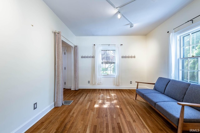 unfurnished room featuring hardwood / wood-style flooring and track lighting