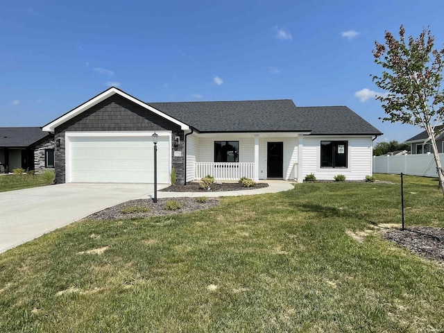 view of front of home featuring covered porch, a front yard, and a garage