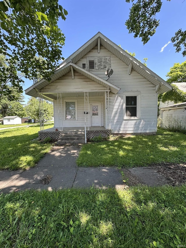 view of front of property with covered porch and a front lawn