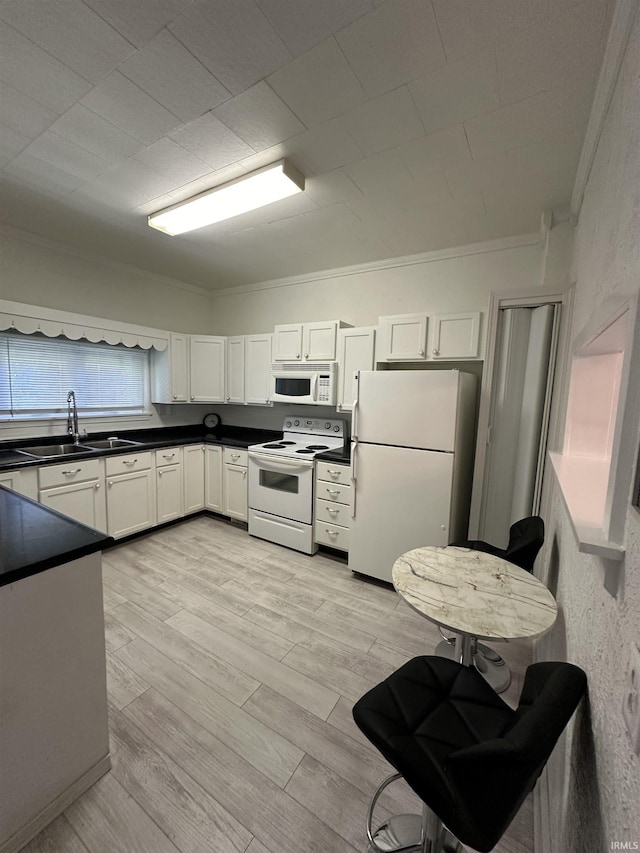 kitchen featuring white cabinetry, sink, light hardwood / wood-style flooring, crown molding, and white appliances