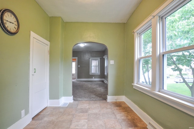 interior space featuring a healthy amount of sunlight and a baseboard radiator