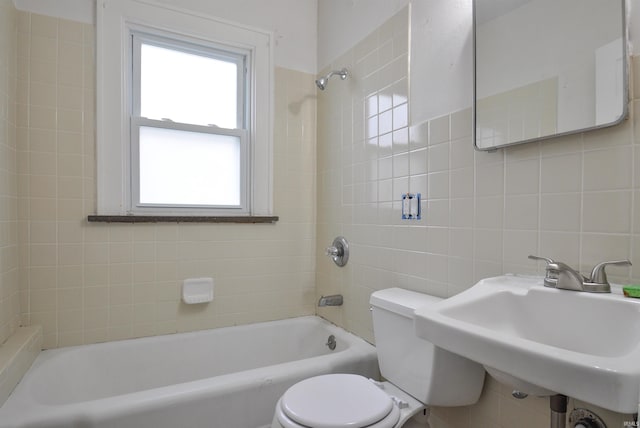 full bathroom featuring tiled shower / bath, sink, tile walls, and toilet