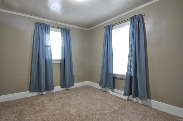 carpeted empty room featuring crown molding