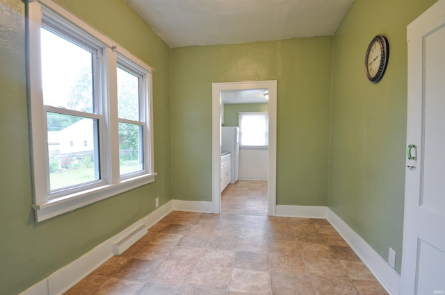 tiled empty room featuring a healthy amount of sunlight and a baseboard radiator