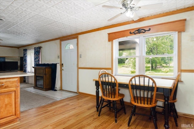 dining room featuring light hardwood / wood-style floors, ceiling fan, and crown molding