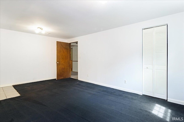 spare room featuring dark colored carpet