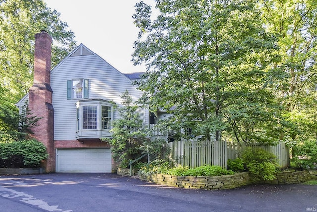 4007 Fairfax Rd, Evansville, IN 47710 - view of front of house with asphalt driveway, an attached garage, and a chimney
