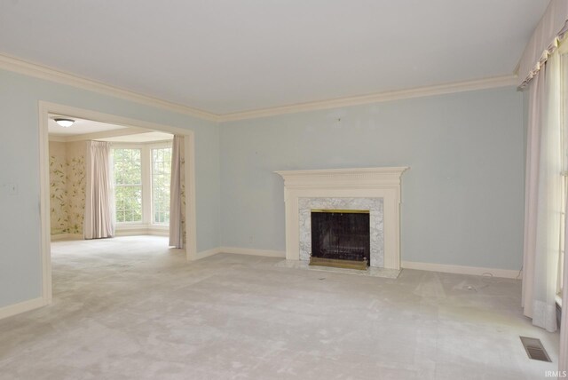 unfurnished living room with crown molding, light carpet, and a fireplace