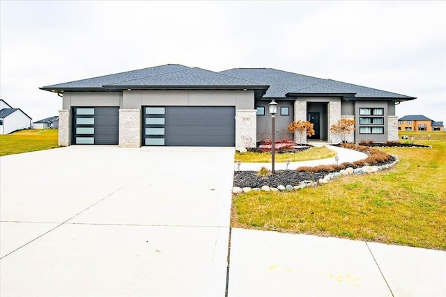 prairie-style home featuring a garage and a front lawn