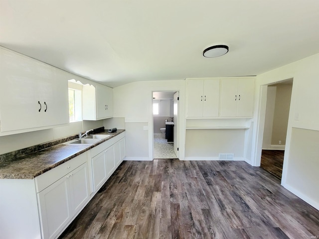 kitchen featuring dark hardwood / wood-style flooring, white cabinetry, sink, and a wealth of natural light