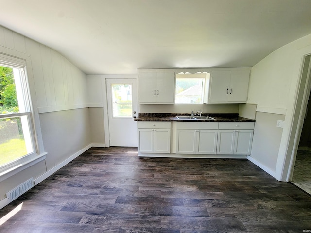 kitchen featuring vaulted ceiling, white cabinetry, and dark wood-type flooring