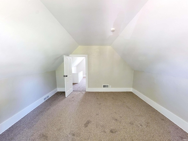 additional living space with carpet floors and vaulted ceiling