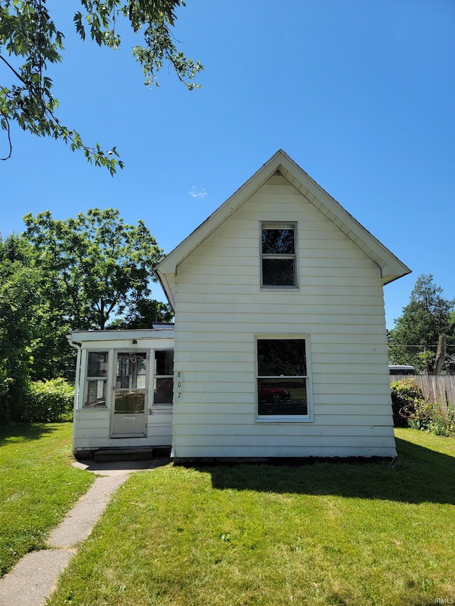 rear view of property featuring a yard