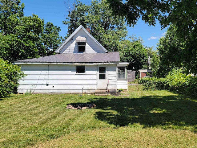 rear view of property featuring a yard