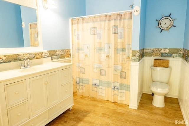 bathroom featuring hardwood / wood-style floors, vanity, toilet, and walk in shower