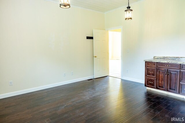 empty room featuring dark wood-type flooring and crown molding