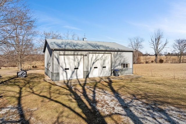 view of outbuilding featuring a lawn and a rural view