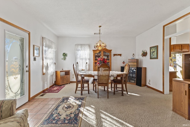 dining room featuring light colored carpet and a textured ceiling