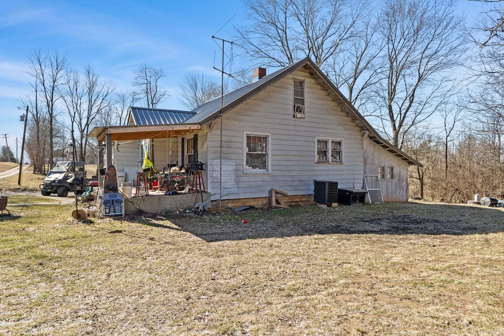 back of house with central AC unit and covered porch