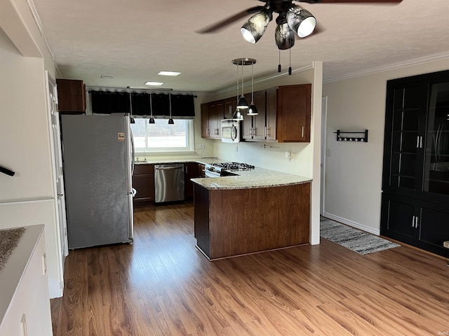 kitchen with dark brown cabinetry, ornamental molding, stainless steel appliances, and light hardwood / wood-style floors