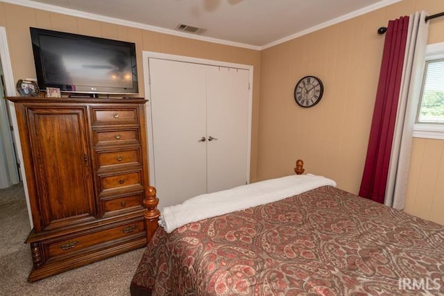 carpeted bedroom with crown molding and a closet