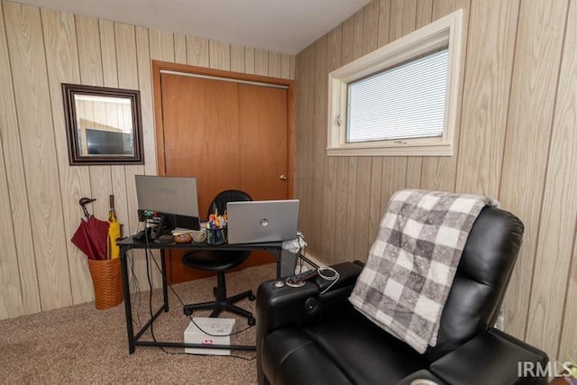 carpeted office space featuring wooden walls