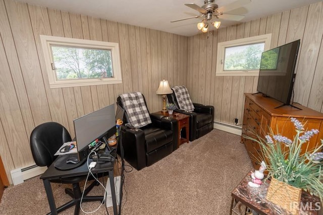 sitting room with carpet, ceiling fan, baseboard heating, and wooden walls