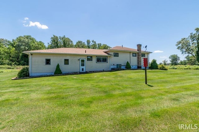 back of property featuring a lawn