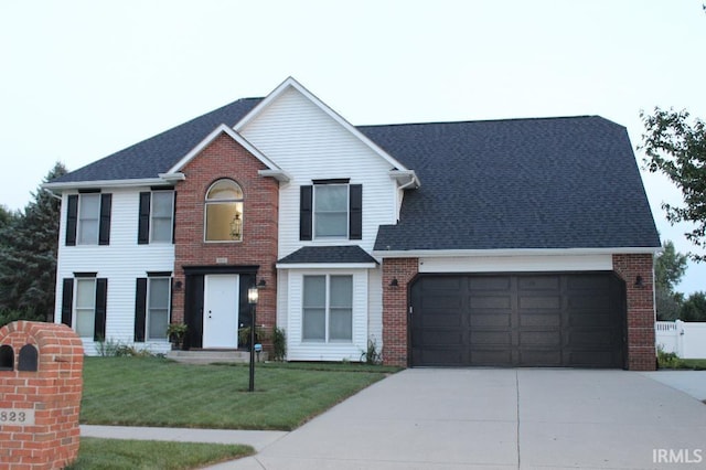 view of front facade featuring a garage, concrete driveway, brick siding, and a front yard