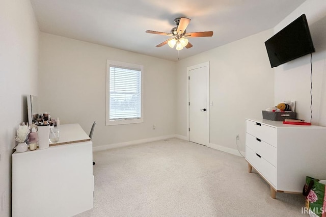 office area featuring light carpet, baseboards, and a ceiling fan