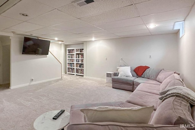 living room featuring light colored carpet, visible vents, a paneled ceiling, and baseboards