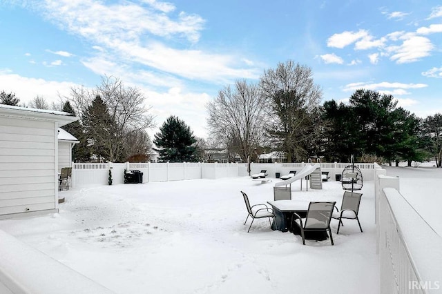 yard covered in snow with a fenced backyard