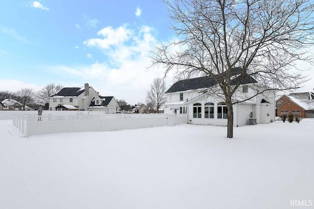 yard covered in snow featuring fence