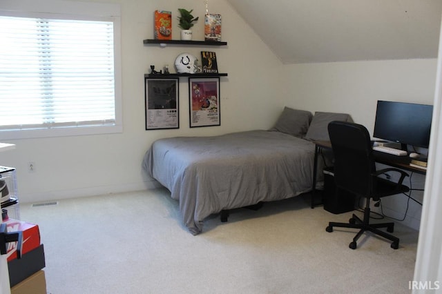 carpeted bedroom with multiple windows and lofted ceiling