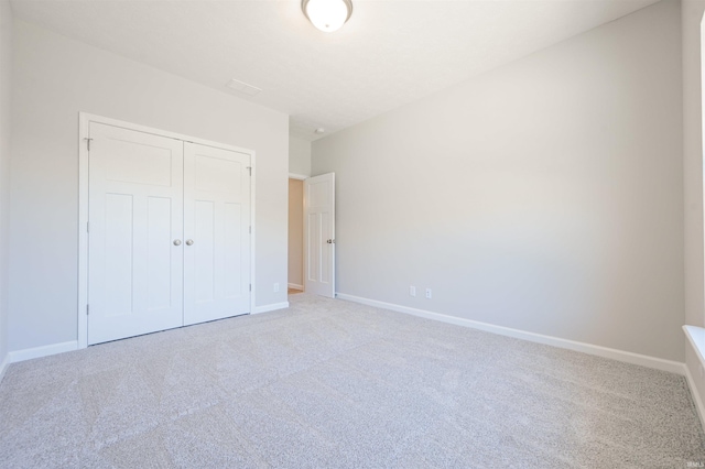 unfurnished bedroom with a closet and carpet floors