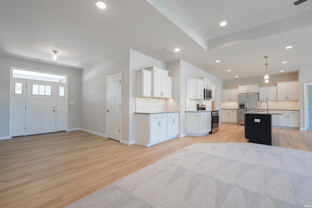 kitchen featuring white cabinetry, an island with sink, and stainless steel appliances