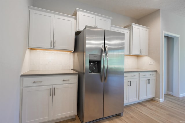 kitchen featuring white cabinets, light hardwood / wood-style floors, stainless steel fridge with ice dispenser, and a textured ceiling